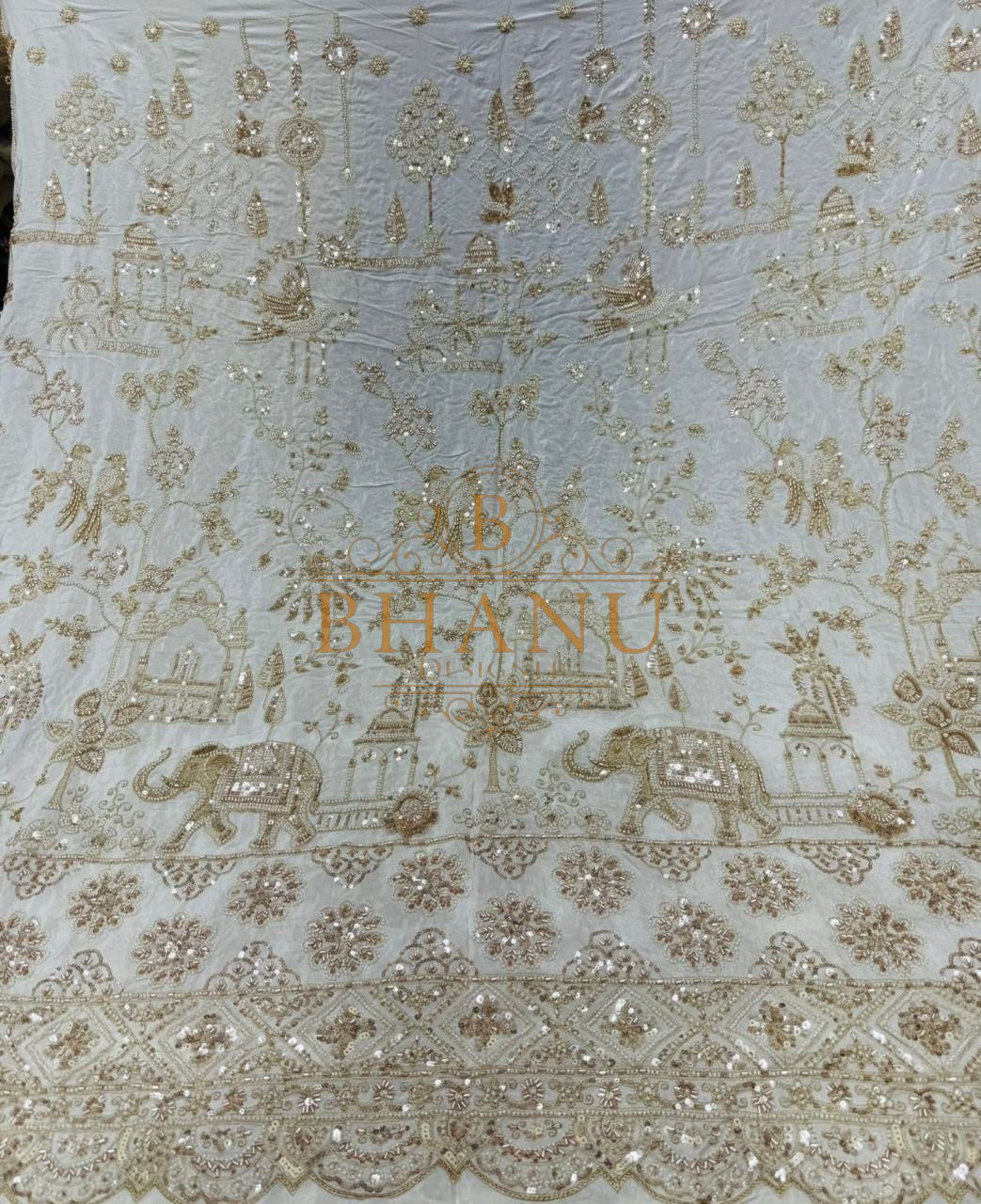 Gold thread elephant and floral work on sheer cream - fabric by the metre
