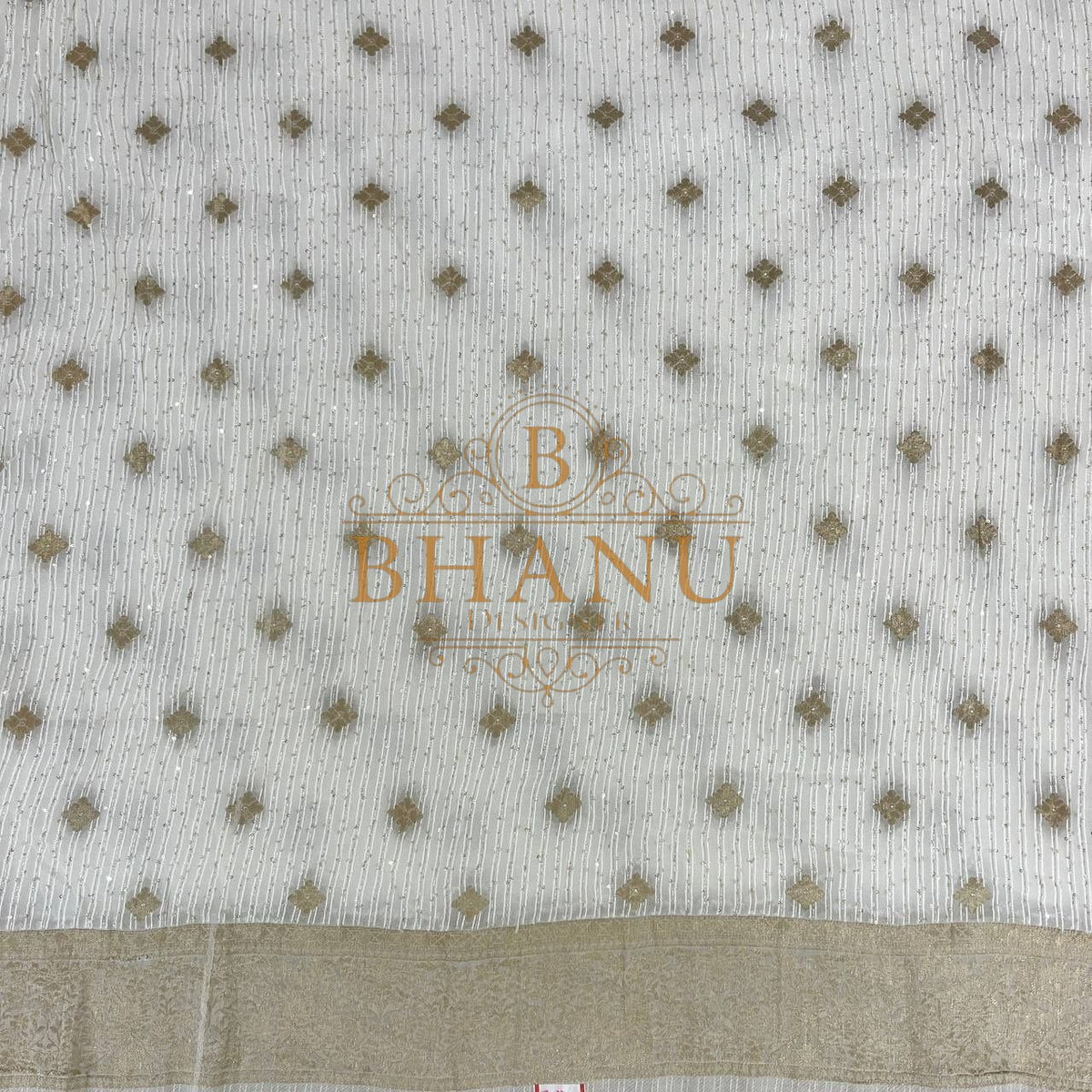 Ivory with gold diamond butti above a woven border - fabric by the metre