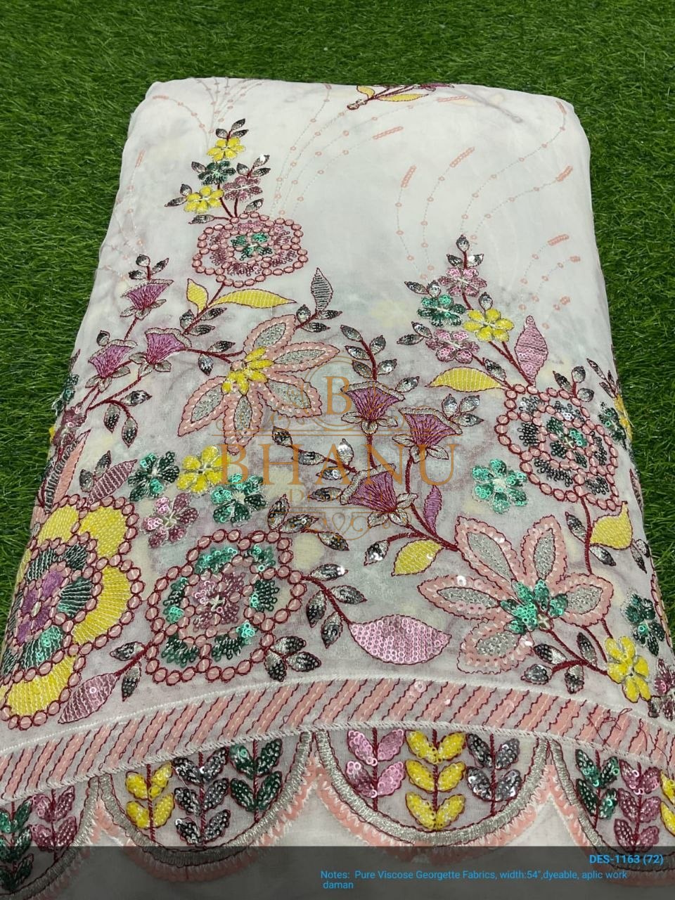 White with multicolour floral applique and a scalloped hem - fabric by the metre