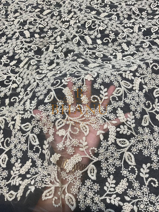 Ivory floral net over a dark ground - fabric by the metre