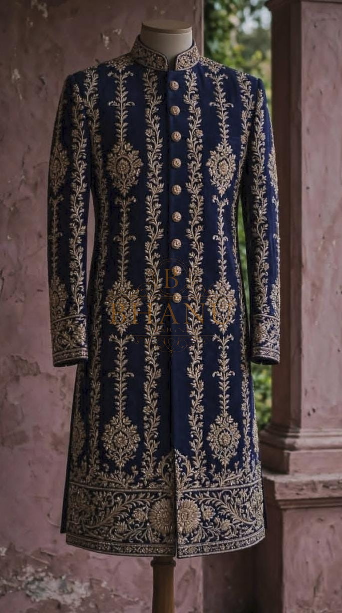 Navy sherwani with columns of gold buttis and a deep embroidered hem