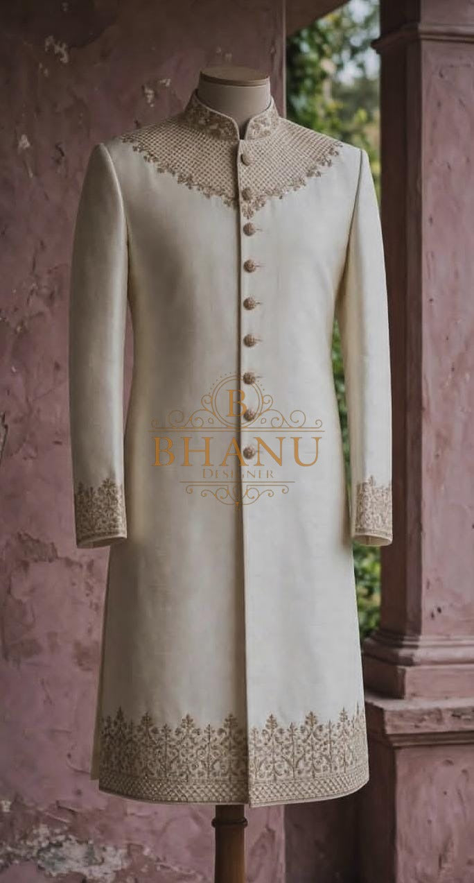 Cream sherwani, plain through the body, with a broad embroidered hem band