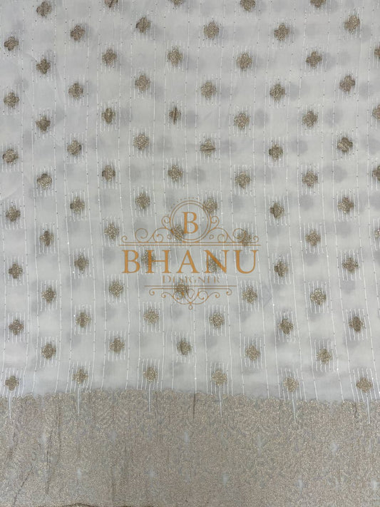 Ivory ground with small gold butti and a woven border - fabric by the metre